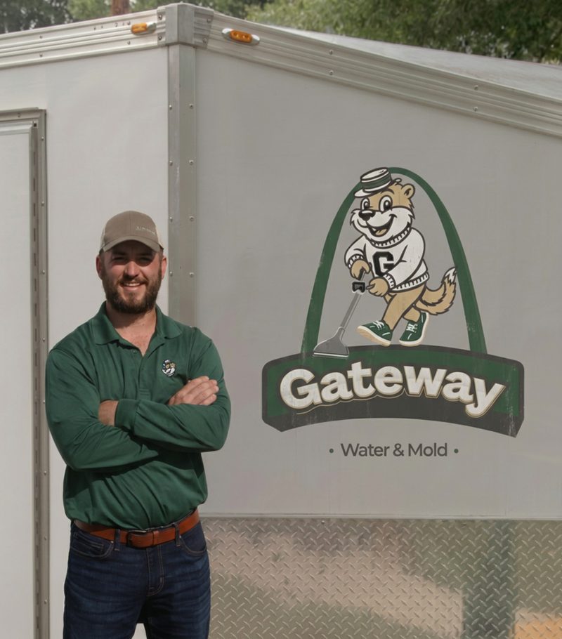 Owner of Gateway Water and Mold standing in front of the company branded equipment trailer