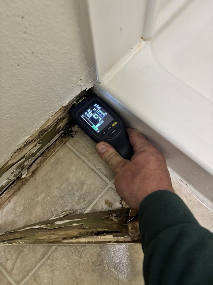 Moisture reading at the shower corner while marking the wet boundary
